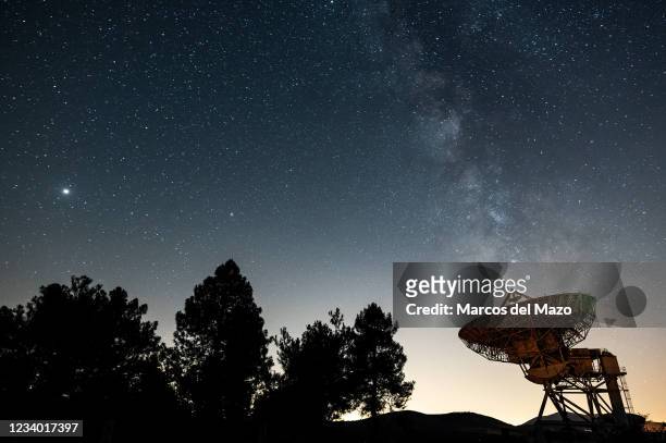 The Milky Way with Jupiter and Saturn , rising over a large dish of the Satellite Communications Center of Buitrago de Lozoya, north of Madrid. The...