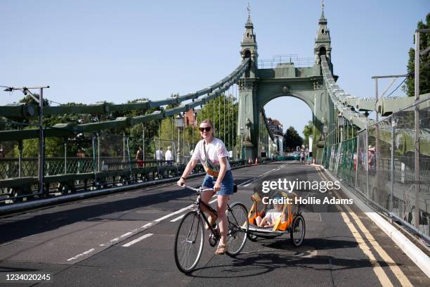 Cyclist rides over the Hammersmith Bridge on July 17, 2021 in Hammersmith, England. The bridge was closed last year after cracks in the bridge...