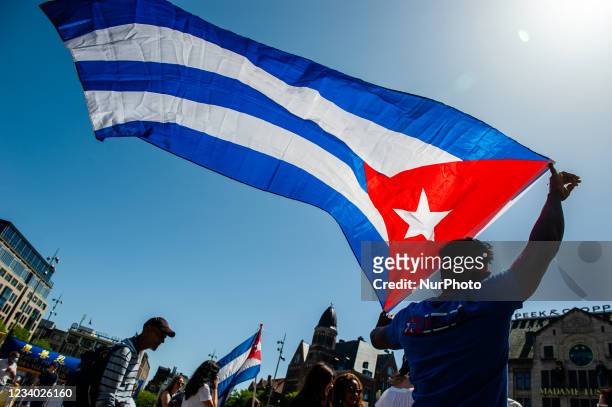 Man is holding a big Cuban flag, during the demonstration in support of Cuba organized in Amsterdam, on July 17th, 2021.