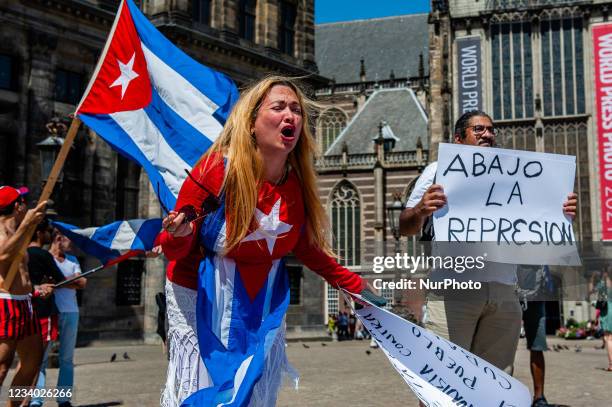 Woman wearing the Cuban flag is giving an emotional speech, during the demonstration in support of Cuba organized in Amsterdam, on July 17th, 2021.