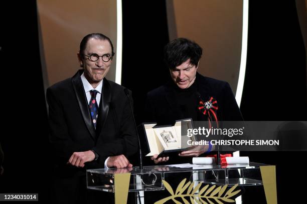 Music composers Ron Mael and Russell Mael pose on stage as they accept the Best Director prize for the film "Annette" on behalf on French director...