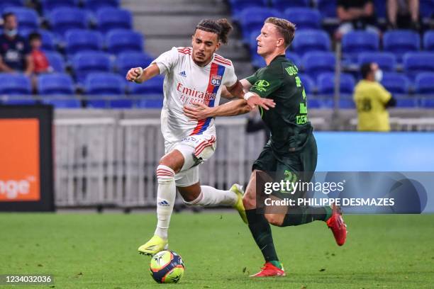 Lyon's French defender Malo Gusto fights for the ball with Wolfsburg's German midfielder Yannick Gerard during the friendly football match between...