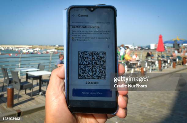 Code with EU COVID digital certificate displayed on a mobile phone in front of a restaurant in Port-en-Bessin-Huppain. On Saturday, July 17 in...