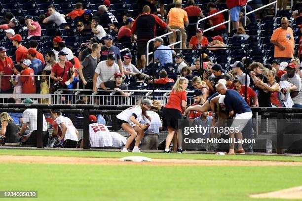 Fans run for cover after what was believed to be shots were heard during a baseball game between the San Diego Padres the Washington Nationals at...