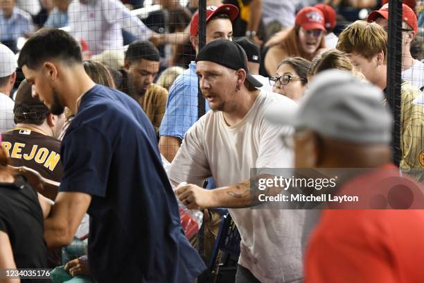 Fans run onto the field for cover after shots are heard from a shooting outside the stadium that sent players and fans seeking shelter during a...