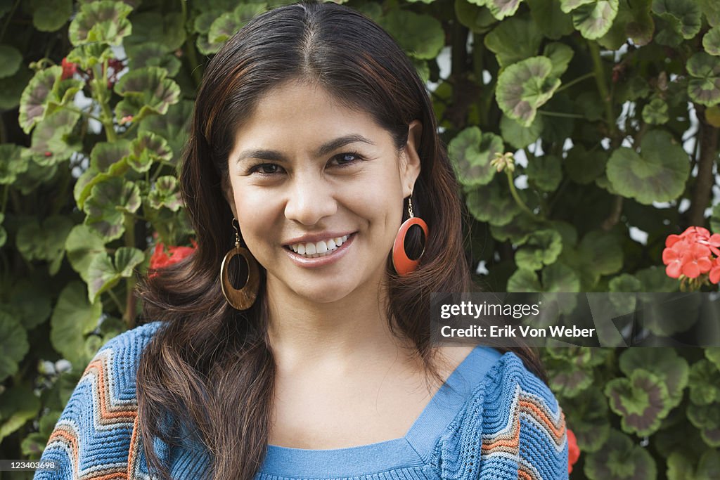 Portrait of latino woman in front of flowers