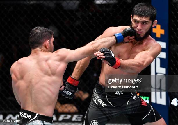 In this handout photo provided by UFC, Thiago Moises of Brazil punches Islam Makhachev of Russia in their lightweight bout during the UFC Fight Night...