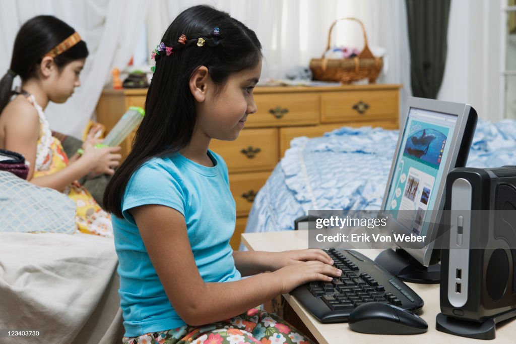 Sisters in their room with desktop computer