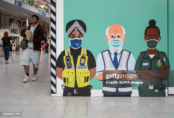 Mural with security professionals wearing facemask is seen inside an underground station in London.Prime Minister Boris Johnson has announced England...