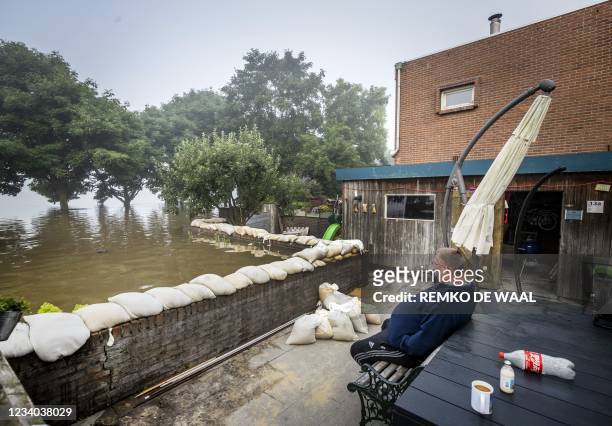 Resident monitors the flood waters from his garden, were he has been sitting over night, in the village of Well on July 18 2021, following heavy...