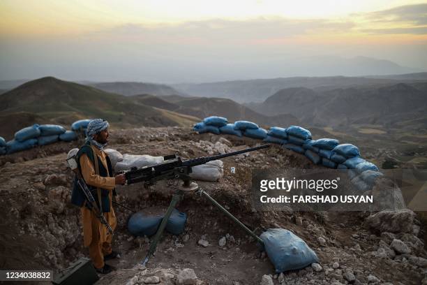 In this picture taken on July 11, 2021 an Afghan militia fighter keeps a watch at an outpost against Taliban insurgents at Charkint district in Balkh...