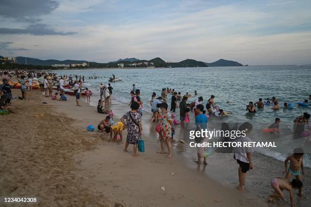 People enjoy bathing at Dadonghai beach in Sanya on China's tropical Hainan Island on July 18, 2021.