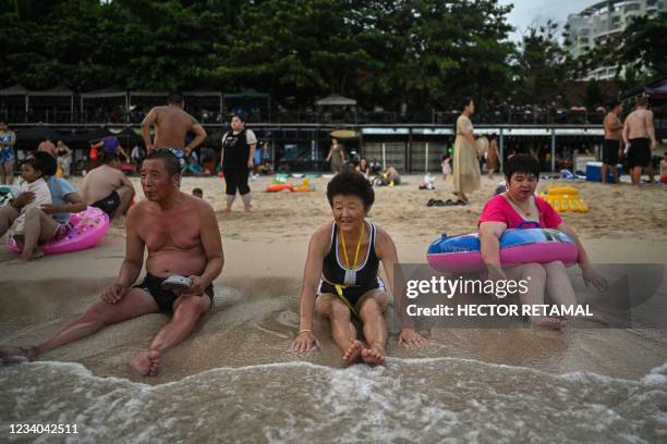 People enjoy bathing at Dadonghai beach in Sanya on China's tropical Hainan Island on July 18, 2021.