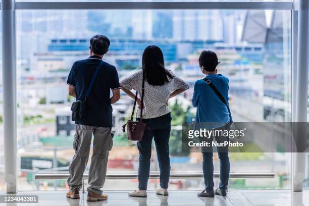 Family watches out of the windows of the airport, hoping to catch a glimpse of the plane leaving with their relatives. On 17 July 2021 in Hong Kong,...
