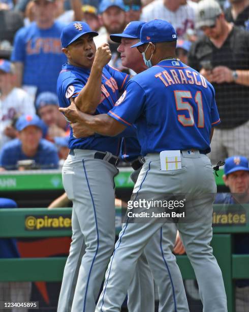 Luis Rojas of the New York Mets is restrained by Tony Tarasco as he argues with home plate umpire Jeremy Riggs after a close play at home plate in...