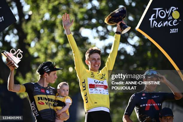 Winner Team UAE Emirates' Tadej Pogacar of Slovenia celebrates his overall leader yellow jersey on the podium at the end of the 21th and last stage...