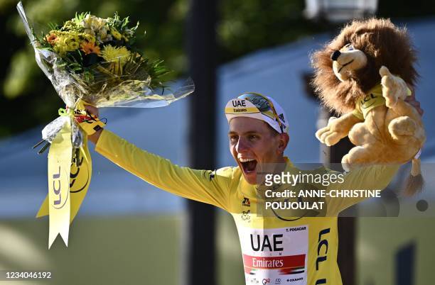 Winner Team UAE Emirates' Tadej Pogacar of Slovenia celebrates his overall leader yellow jersey on the podium at the end of the 21th and last stage...