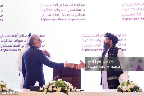 The head of Afghanistan's High Council for National Reconciliation Abdullah Abdullah prepares to shake hands with the leader of the Taliban...