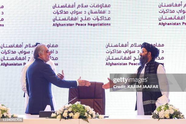 The head of Afghanistan's High Council for National Reconciliation Abdullah Abdullah prepares to shake hands with the leader of the Taliban...