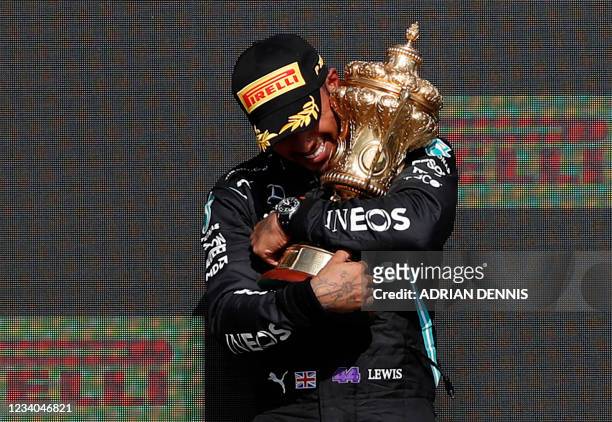 Winner Mercedes' British driver Lewis Hamilton holds the trophy on the podium after the Formula One British Grand Prix motor race at Silverstone...