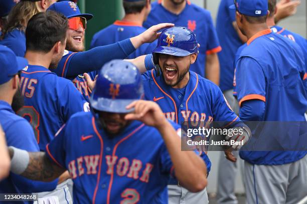 Michael Conforto of the New York Mets reacts in the dugout with teammates after hitting a two run home run in the ninth inning during the game...