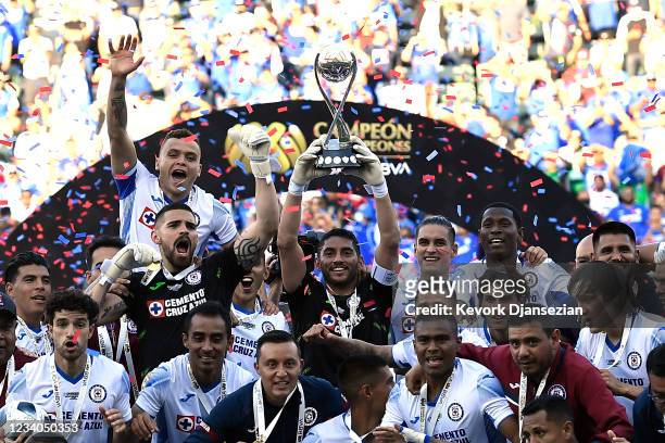 Goalkeeper Jesús Corona of Cruz Azul lifts the championship trophy as he celebrates with his teammates after winning a match between Cruz Azul and...