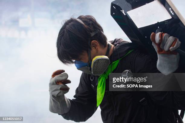 Protester holds a shield while standing in the massive fog of tear gas during the demonstration. The Anti-government group rally gathered at the...