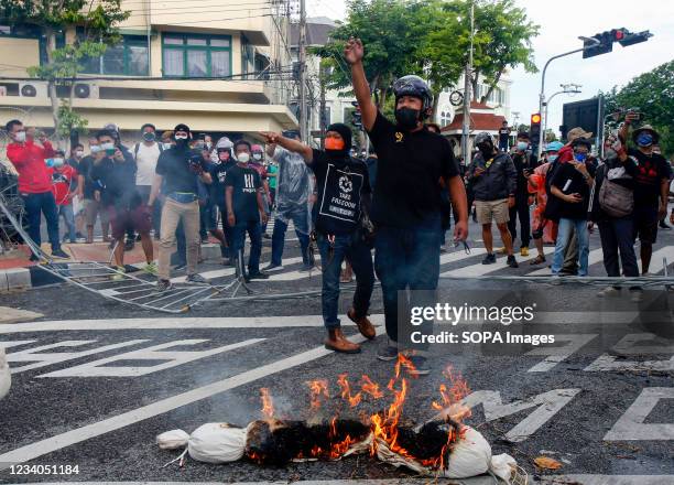Protesters burn a simulate of the dead covid 19 victims, during the demonstration outside Government House. Police in Bangkok fired water cannons,...