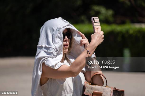 Tourist is seen covering her head from the sun and heat in the museum area of Montjüic mountain. According to the State Meteorological Agency , an...