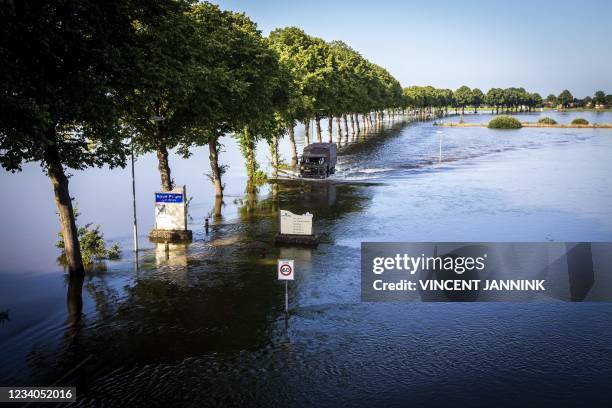 Residents cross a flooded area between Bergen and Nieuw Bergen, on board a shuttle service, operated by Dutch army, on July 19, 2021 after a major...