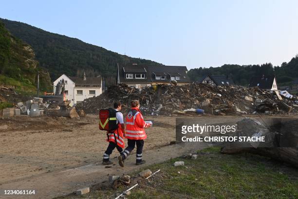 Emergency workers walk in a street in Altenburg, Rhineland-Palatinate, western Germany, on July 19 after devastating floods hit the region. - The...