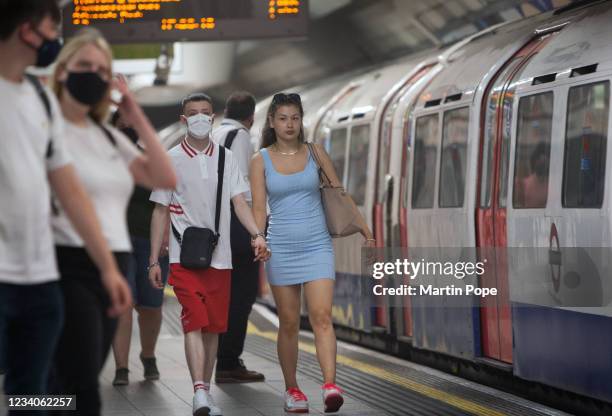 Young couple on the platform at Oxford Circus, one choosing a mask the other goes without on July 19, 2021 in London, United Kingdom. As of 12:01 on...