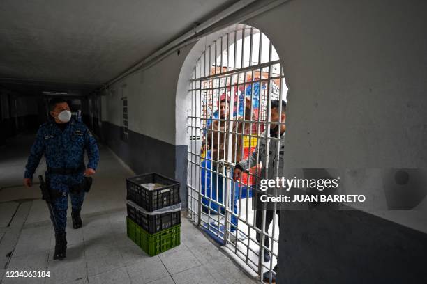 Guard walks past prisoners at "La Picota" prison in Bogota on July 19 as a vaccination plan againt COVID-19 takes place.
