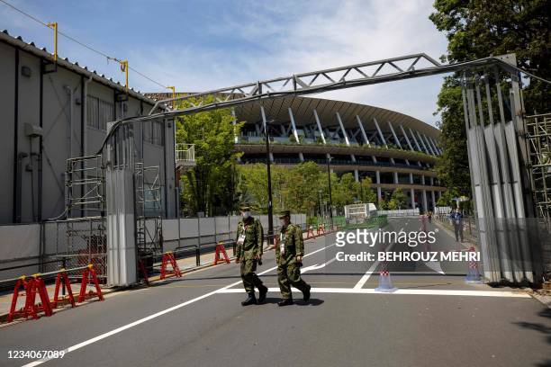 Police officers walk in front of the Olympic Stadium in Tokyo on July 20, 2021 ahead of the Tokyo 2020 Olympic Games.