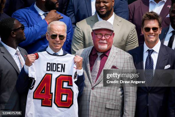President Joe Biden holds up a Buccaneers jersey while standing next to head coach Bruce Arians and quarterback Tom Brady as he welcomes the 2021 NFL...