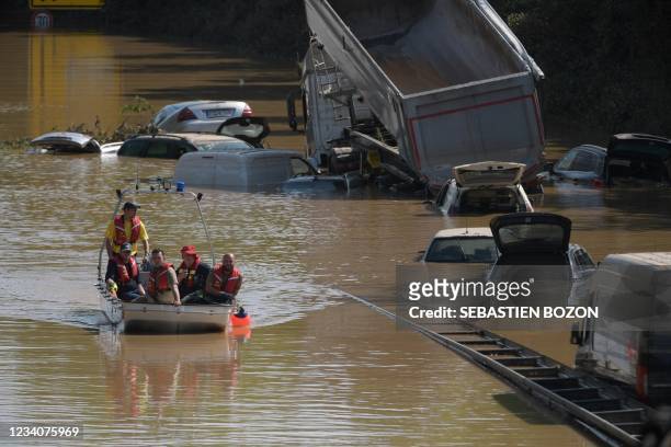 Rescue boat patrols next to submerged cars and other vehicles on a flooded section of the federal highway B265 in Erftstadt, western Germany, on July...