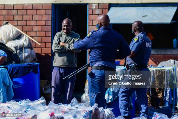 Police go door to door to confiscate suspected looted goods at Mansel Market in the Central Business District on July 19, 2021 in Durban, South...