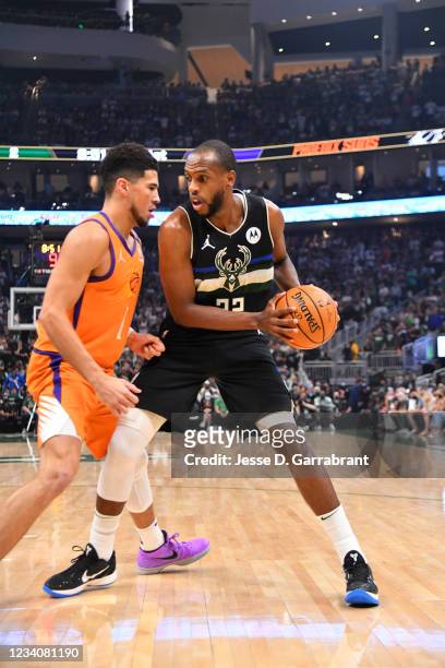 Khris Middleton of the Milwaukee Bucks handles the ball against Devin Booker of the Phoenix Suns during Game Six of the 2021 NBA Finals on July 20,...