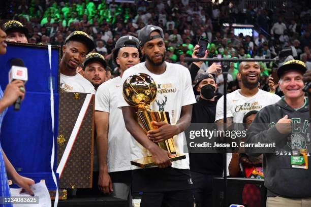 Khris Middleton of the Milwaukee Bucks celebrates with the Larry O'Brien Trophy after winning Game Six of the 2021 NBA Finals against the Phoenix...