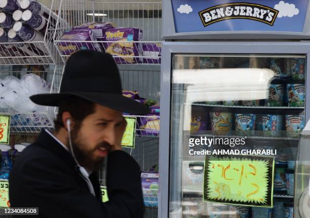 An Ultra Orthodox Jewish man walks by Ben & Jerry's ice cream in Jerusalem on July 20, 2021. - American ice cream-maker Ben & Jerry's announced on...
