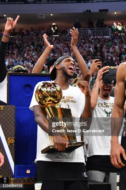 Khris Middleton of the Milwaukee Bucks celebrates with the Larry O'Brien Trophy after winning Game Six of the 2021 NBA Finals against the Phoenix...