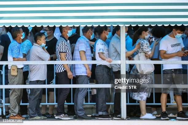 Residents queue to receive nucleic acid tests for the Covid-19 coronavirus in Nanjing, in eastern Jiangsu province on July 21, 2021. - China OUT /...