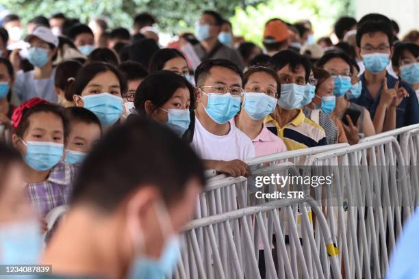 Residents queue to receive nucleic acid tests for the Covid-19 coronavirus in Nanjing, in eastern Jiangsu province on July 21, 2021. - China OUT /...