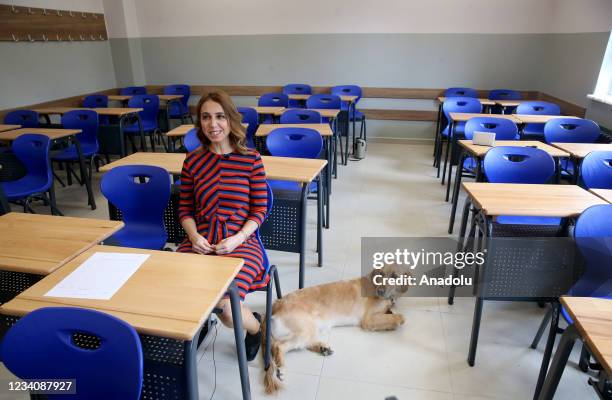 Havva Ipek Yener, a 35-year-old history teacher who lost her sight 20 years ago sits on a chair in a classroom as her guide dog "Angel" lies near her...