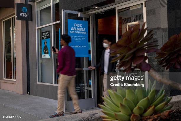 Customers exit an AT&T store in Emeryville, California, U.S., on Tuesday, July 20, 2021. AT&T Inc. Is scheduled to release earnings figures on July...