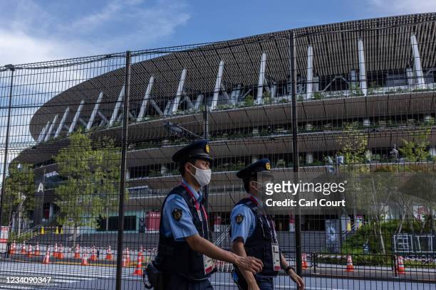 Police officers wearing face masks patrol next to Tokyo Olympic stadium on July 21, 2021 in Tokyo, Japan. With just two days until the Olympics...