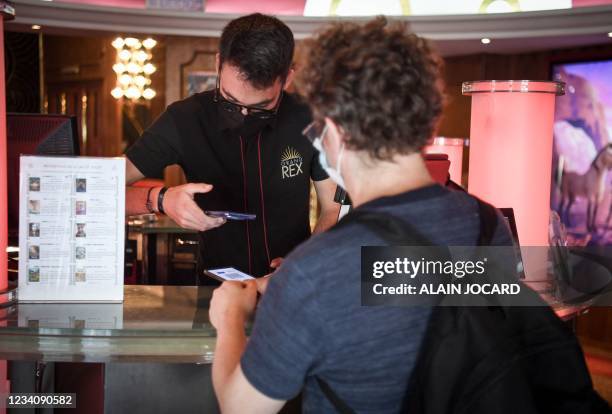 Spectators have their health passport checked before they enter Grand Rex cinema to watch the screening of Kaamelott, directed by French Alexandre...