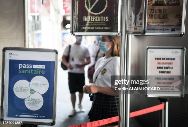 Spectators, wearing masks, queue before they have their health passport checked as they enter Grand Rex cinema to watch the screening of Kaamelott,...