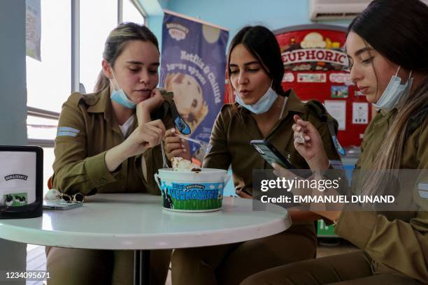 Three Israeli soldiers enjoy ice-cream at a shop inside the Ben & Jerry's factory in Be'er Tuvia in southern Israel, on July 21, 2021. - Ben &...