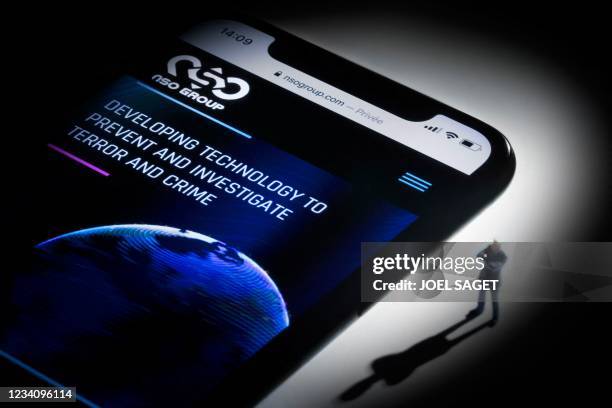 This studio photographic illustration shows a smartphone with the website of Israel's NSO Group which features 'Pegasus' spyware, on display in Paris...